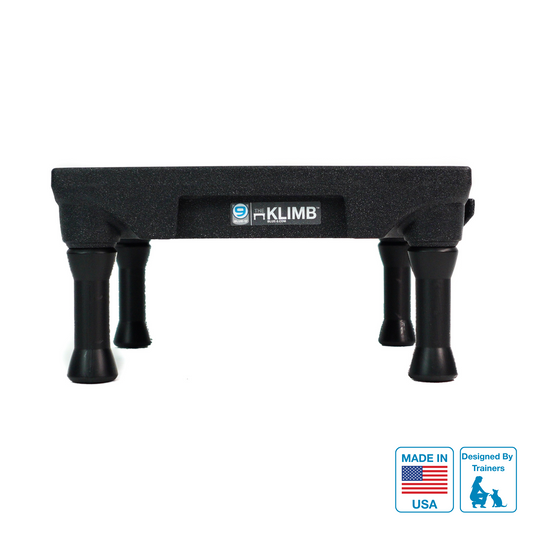 A black KLIMB dog training platform with the KLIMB brand logo, marked as made in the USA, with removable legs.